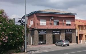 a car parked in front of a brick building at Pensión Puerto Rico in Monteagudo