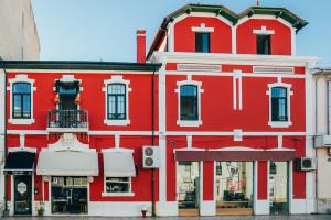 a red building with a balcony on the side of it at Dona Fina Guest House in Mirandela