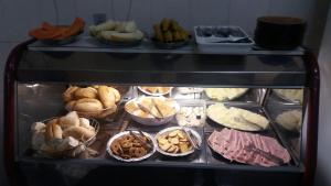a display case filled with different types of food at Hotel Santa Rita in Aparecida