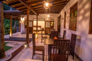 a patio with tables and chairs and a dining area at Villa Eco Pearl in Hikkaduwa