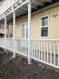 a white fence on a house with a porch at Ahi Hale in Kailua-Kona