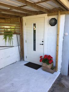 a front door of a house with a potted plant at Rum i villa - Kärleksudden Norrtälje in Norrtälje