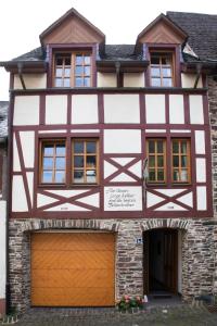 a half timbered house with a garage at Ferienhaus Marie in Bremm