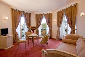 un salon avec un canapé, une table et des chaises dans l'établissement Grand Hôtel Moderne, à Lourdes