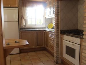 een keuken met een witte koelkast en een raam bij Villa Pepito in Riumar