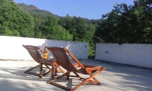 2 ligstoelen en een tafel op een patio bij Casa Amarante Porto in Amarante