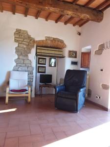 uma sala de estar com uma cadeira e uma parede de pedra em Country house near Florence em Florença
