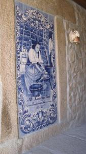 a picture of a woman in a chair on a wall at A Queijaria in Barreira