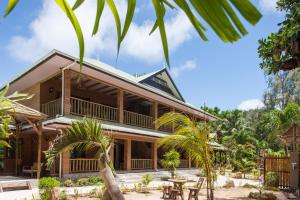 a house with palm trees in front of it at Anse Severe Beach Villas in La Digue