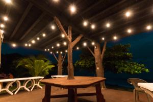 eine Terrasse mit einem Holztisch und Lampen in der Unterkunft Big Daddy's Beach Club & Hotel in Puerto Armuelles