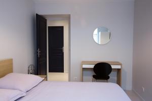 een slaapkamer met een bed, een bureau en een stoel bij Apart By Jo - Proc 2D in Saint-Germain-en-Laye
