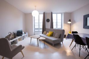 un soggiorno con divano e tavolo di Apart By Jo - Proc 2D a Saint-Germain-en-Laye