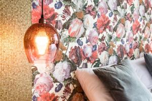 a bedroom with a floral wallpaper and a lamp at Rijksmonument Hotel de Sprenck in Middelburg
