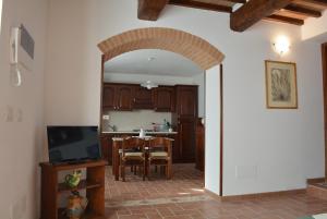 uma cozinha e sala de jantar com um arco aberto em Babbo Rino em Vagliagli