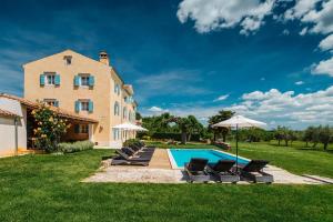 a villa with a swimming pool in front of a building at Villa Stanzia Cocci in Brtonigla