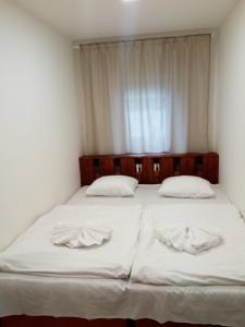 1 dormitorio con 2 camas con sábanas blancas y ventana en ZOOPARK Zelčín, en Mělník