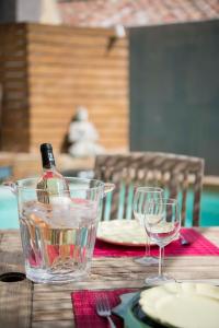 リル・シュル・ラ・ソルギュにあるUn Ryad a l'Isleのグラス付きテーブルに座るワイン1本