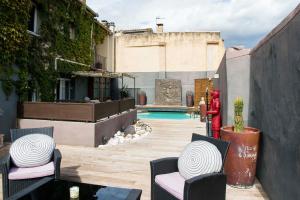 an outdoor patio with chairs and a swimming pool at Un Ryad a l'Isle in L'Isle-sur-la-Sorgue
