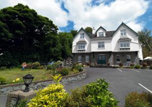 una gran casa blanca con entrada en Woodlawn House, en Killarney