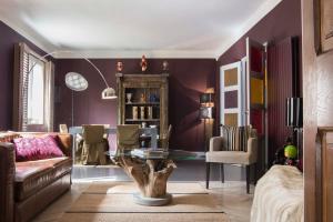 a living room with purple walls and a table at Un Ryad a l'Isle in L'Isle-sur-la-Sorgue
