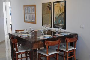 a wooden table with chairs and plates and glasses on it at Shmulik Galilee in Lavon