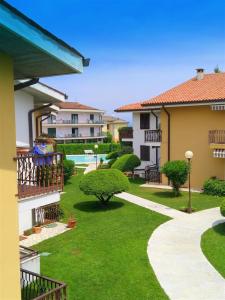 dziedziniec domu z zieloną trawą i drzewami w obiekcie Casa Sant Elena ID15675 w mieście Peschiera del Garda