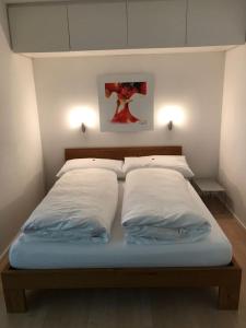 ダボスにあるFerienwohnung Parkareal Davosの白い枕2つが備わるドミトリールームのベッド1台分です。
