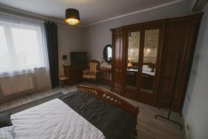 a bedroom with a bed and a desk and a mirror at Apartamenty Blisko Centrum in Toruń