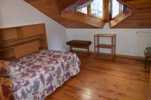 1 dormitorio con 1 cama y suelo de madera en Ca L'Emili, en Llagunes