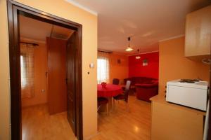 茲拉蒂博爾的住宿－Guesthouse Vila Stakic，厨房以及带红色桌子的用餐室。