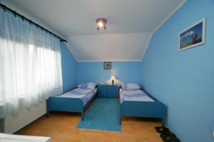 een kamer met 2 bedden en een blauwe muur bij Guesthouse Vila Stakic in Zlatibor