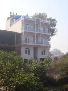 a white building with a balcony on top of it at Ray of Maya in Agra