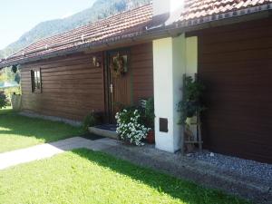 a brown house with a door with flowers on it at Ferienhütte in Ruhpolding in Ruhpolding +10 photos
