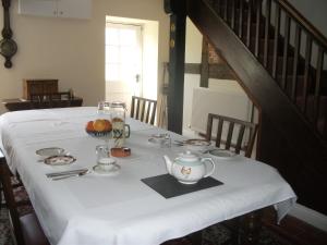 ウェルシュプールにあるVarchoel Hall Guilsfieldの白いテーブルクロスと急須付きテーブル