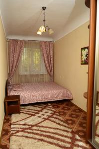 1 dormitorio con cama rosa y ventana en Apartment on Petropavlivs'ka 90, en Sumy