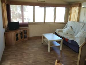 una pequeña sala de estar con sofá y mesa. en Camping Iznate, en Iznate