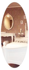 een badkamer met een spiegel en een bed in een kamer bij Ya Tai Hotel in Liugui