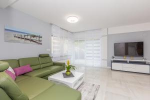 un soggiorno con divano verde e TV di Villa Nika a Malinska