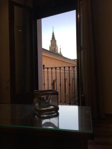 トレドにあるTeatro Rojas IIの建物の景色を望むガラス張りのテーブル