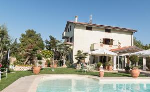 a villa with a swimming pool in front of a house at Il Giardino degli Angeli in Rivotorto 