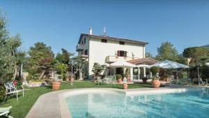 a villa with a swimming pool in front of a house at Il Giardino degli Angeli in Rivotorto 