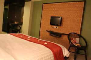 a bedroom with a bed and a tv on a wall at Lamoon Lamai Residence & Guesthouse in Lamai