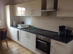 a kitchen with white cabinets and a black counter top at Mountain View Rooms in Kindsbach