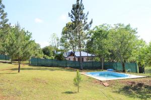 a swimming pool in a yard with a fence at Las Cabanas in Jardín América