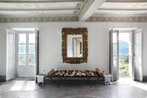 a white room with a table and a mirror on the wall at Palazzo dei Leoni in Ameno