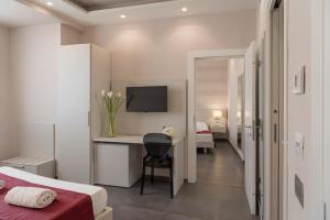 a bedroom with a bed and a desk with a television at Grand Hotel Biffy in Ariano Irpino