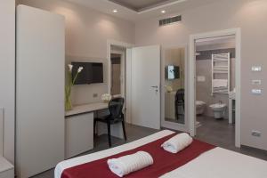 sypialnia z łóżkiem i biurkiem oraz łazienka w obiekcie Grand Hotel Biffy w mieście Ariano Irpino