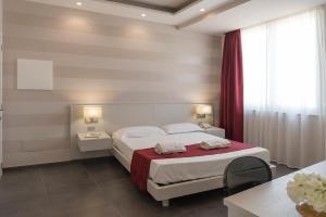 a bedroom with a bed with a red blanket at Grand Hotel Biffy in Ariano Irpino