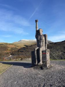 Una estatua de un gato parado en medio de una carretera. en No21 Hop to Zipworld, en Bethesda