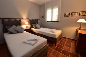 een kamer met twee bedden en een raam bij Ktima Grammeno Beachside Villa in Palaiochóra